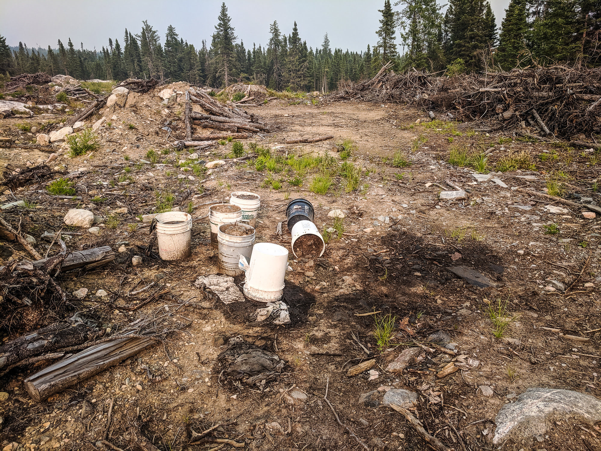 Pails of dirty oil spill onto contaminated ground in Nopiming Provincial Park, violating the law.