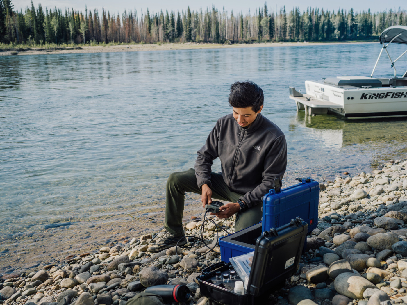 Jordan, a Kaska land guardian, conducts water sampling along the Kechika River in northern B.C. Photo: Taylor Roades / The Narwhal