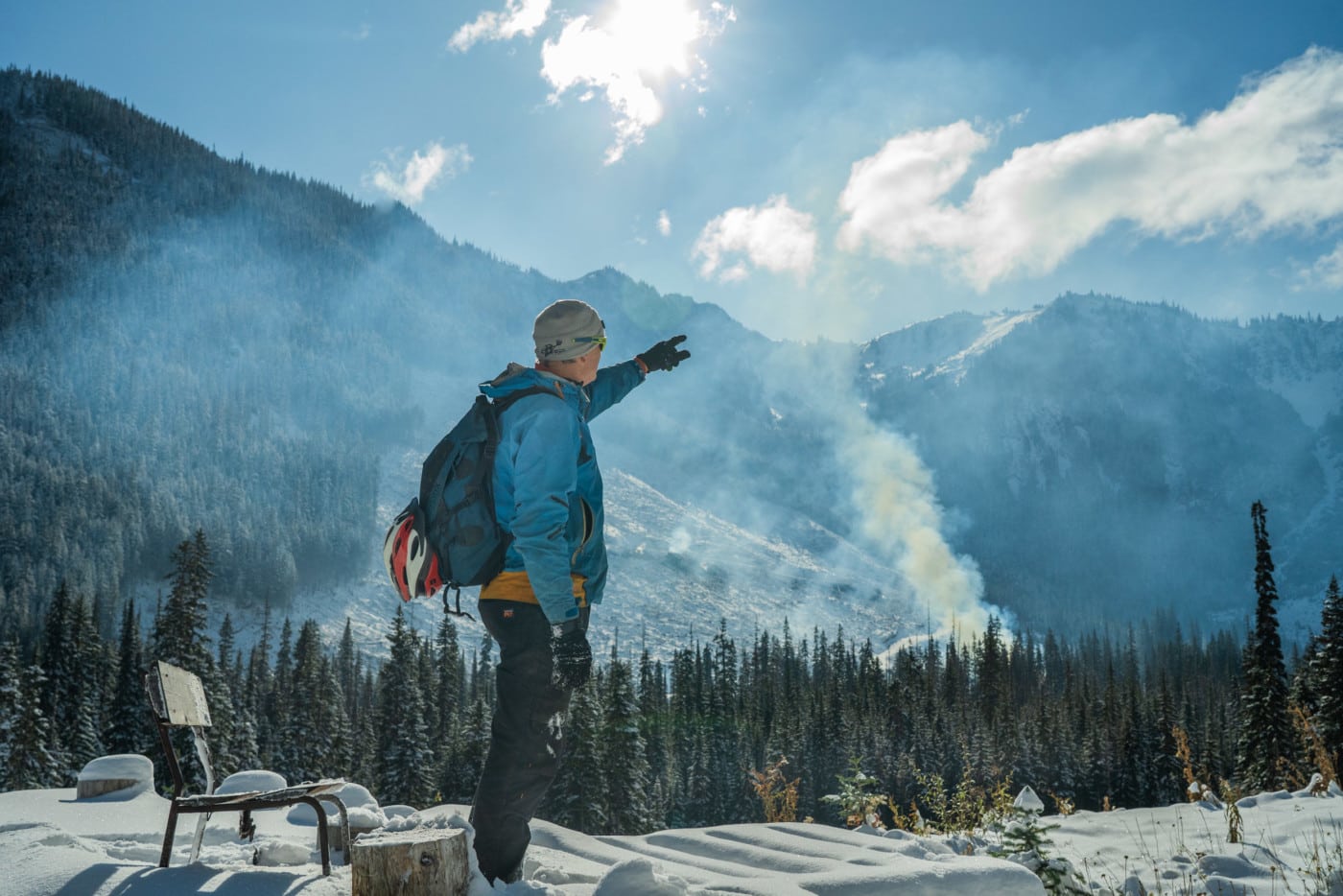 Paul Berntsen stands at the foundation of his yurt, from which he hoped to operate a non-motorized eco-tourism company before his permits were denied. The Silverdaisy peak in Manning Park and a recent clear cut are obscured by smoke from ongoing burning of waste wood. Photo: Fernando Lessa / The Narwhal