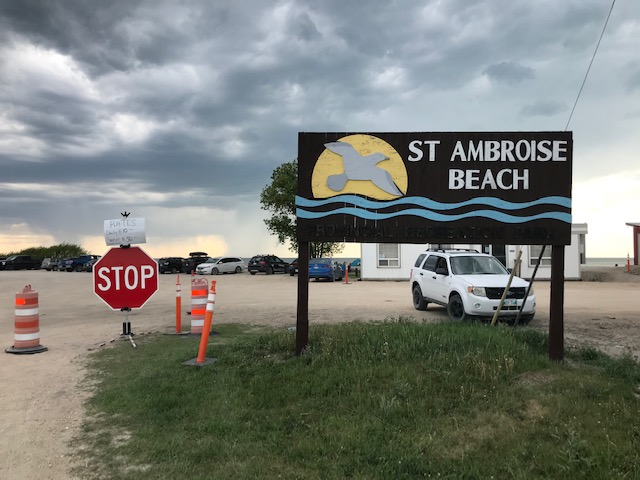 The sign and parking lot at St. Ambroise Beach