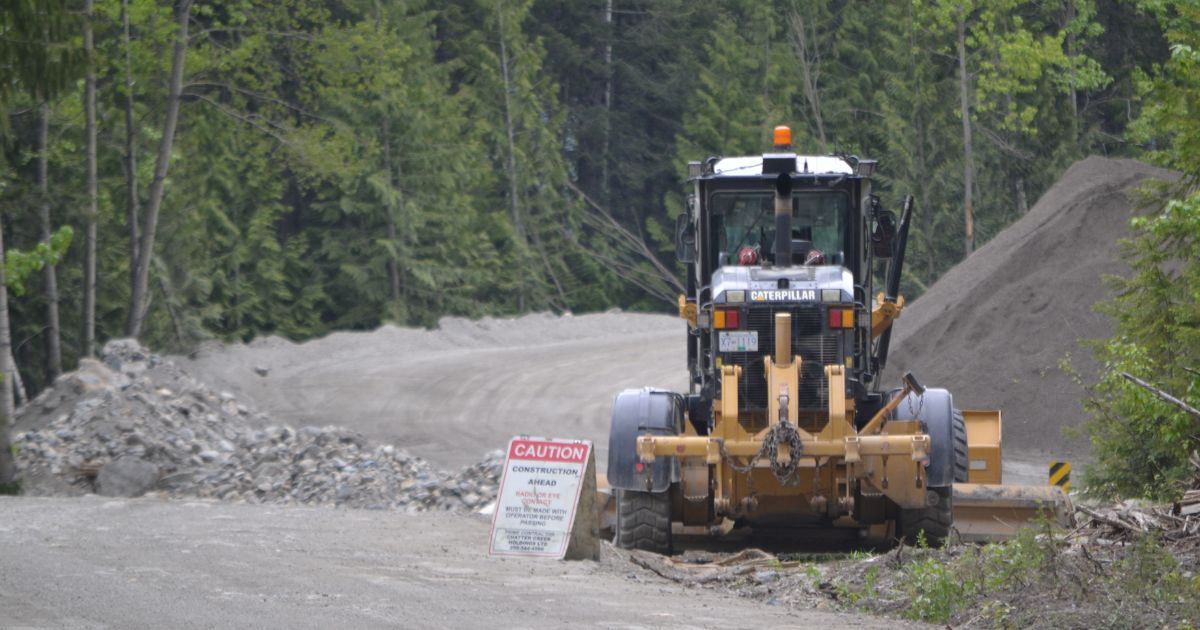 Construction truck in a mining site in the forest. End of image description. 