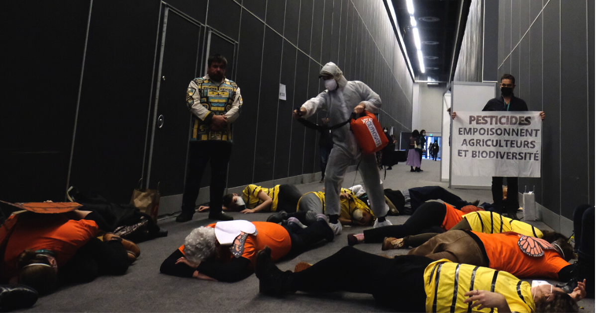 Protestors dressed as pesticide sprayer and dead pollinators. End of image description. 