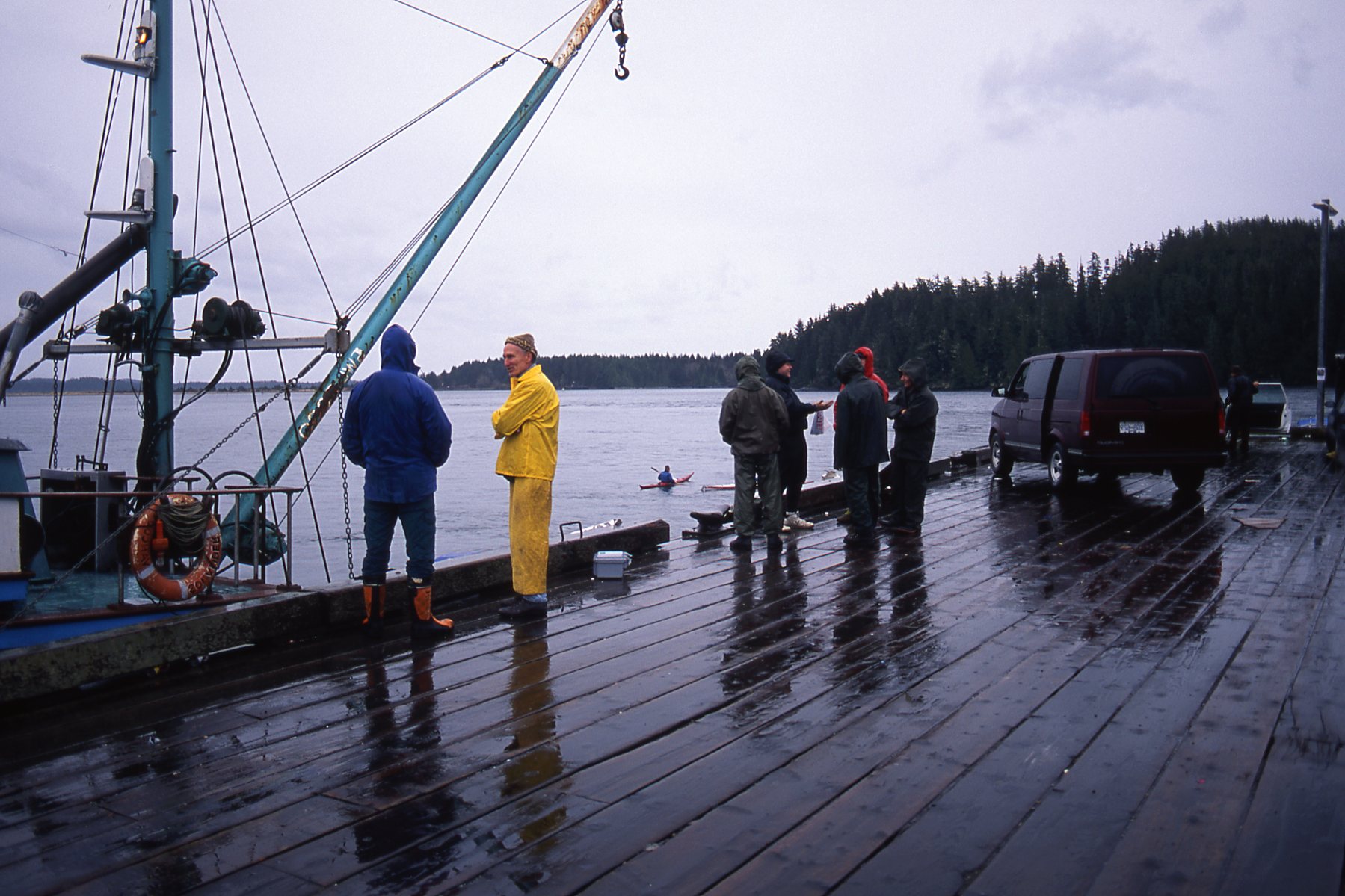 Several people stand on a dock in the rain in Ahousaht territory