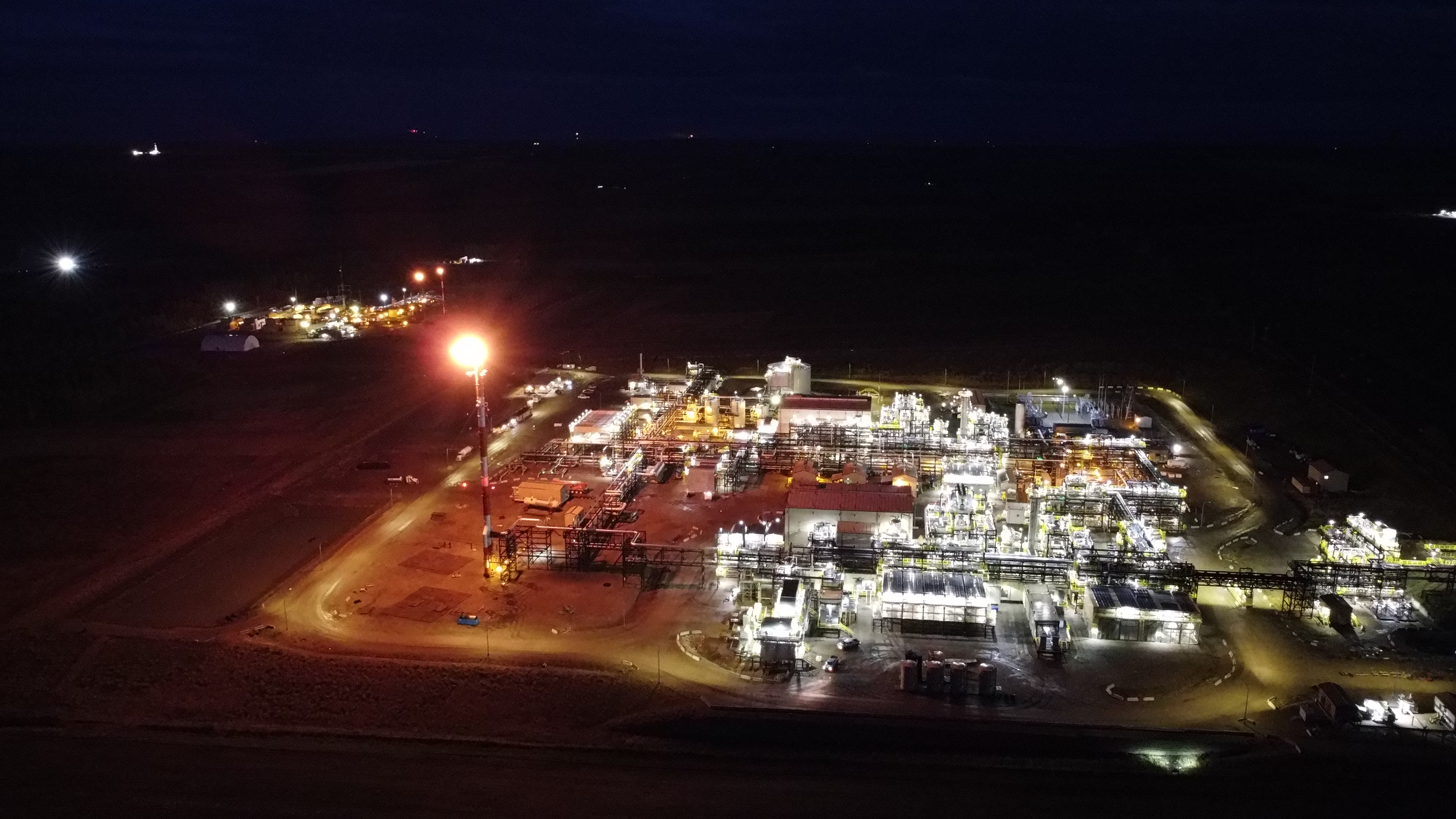 A gas plant at night, with flares going off. End of image description.