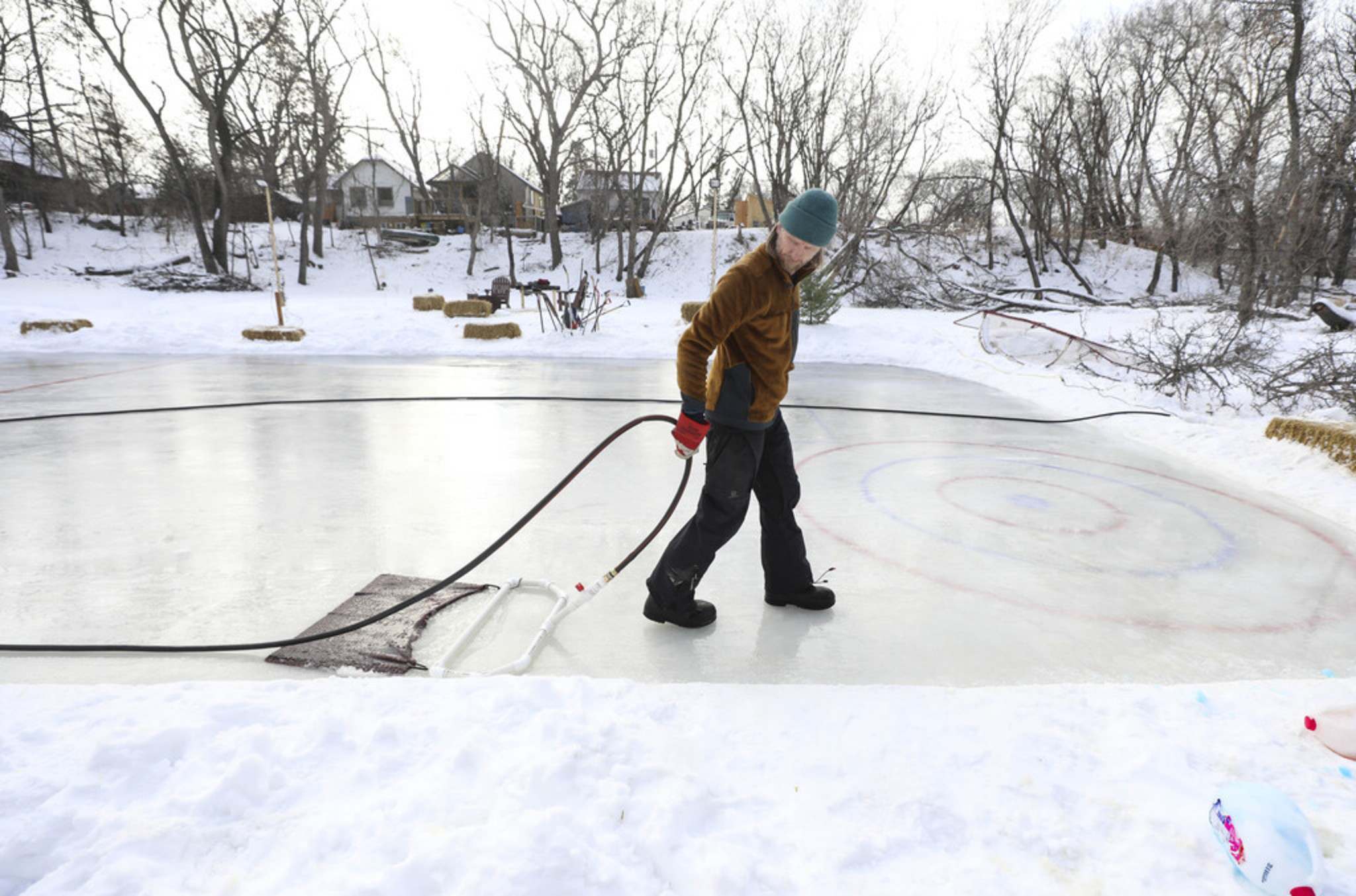 RUTH BONNEVILLE / WINNIPEG FREE PRESS  Eric Reder uses a homemade zamboni to flood his rink that he made on the Seine River in front of his home. He can’t believe how much work is going into maintenance of the rink because it won’t stay frozen — in Winnipeg — in January.