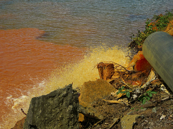 Brown water, supposedly treated, flows from a pipe from the Sherridon mine