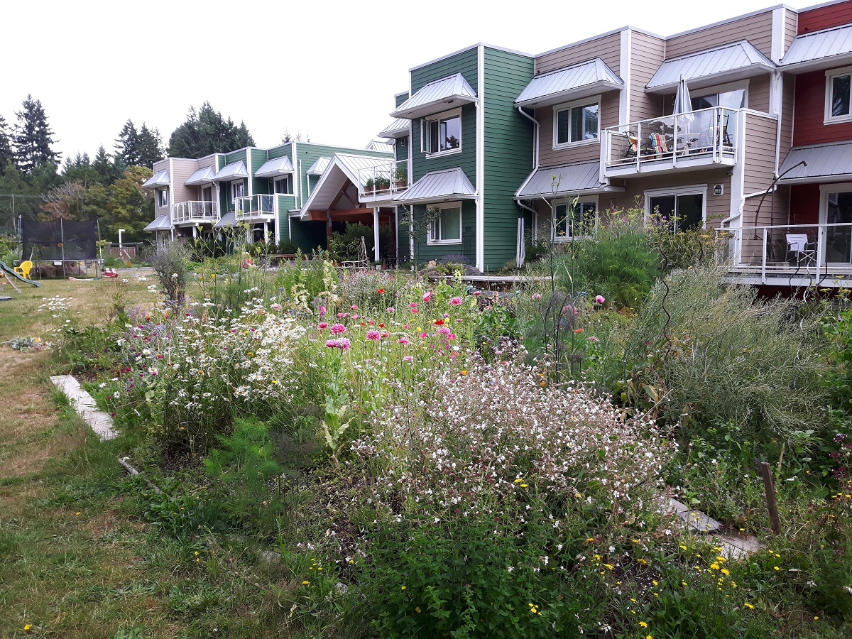 Photo of a co-op housing complex with a garden in the front. End of image description.
