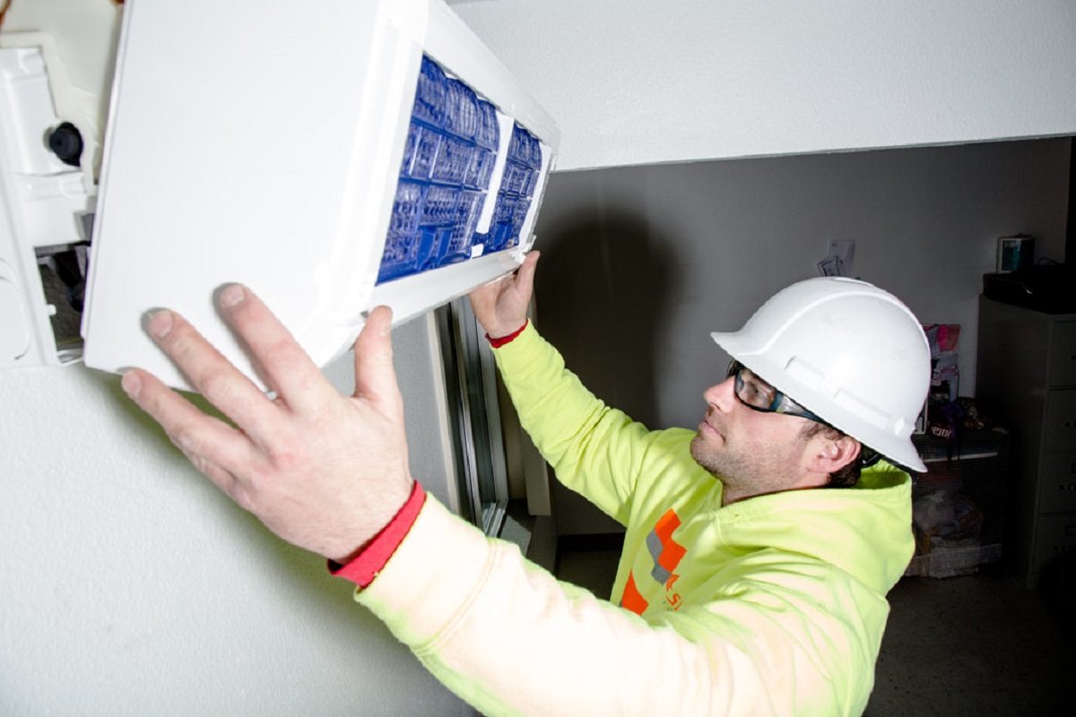 Construction worker installs new heat pump. End of image description.