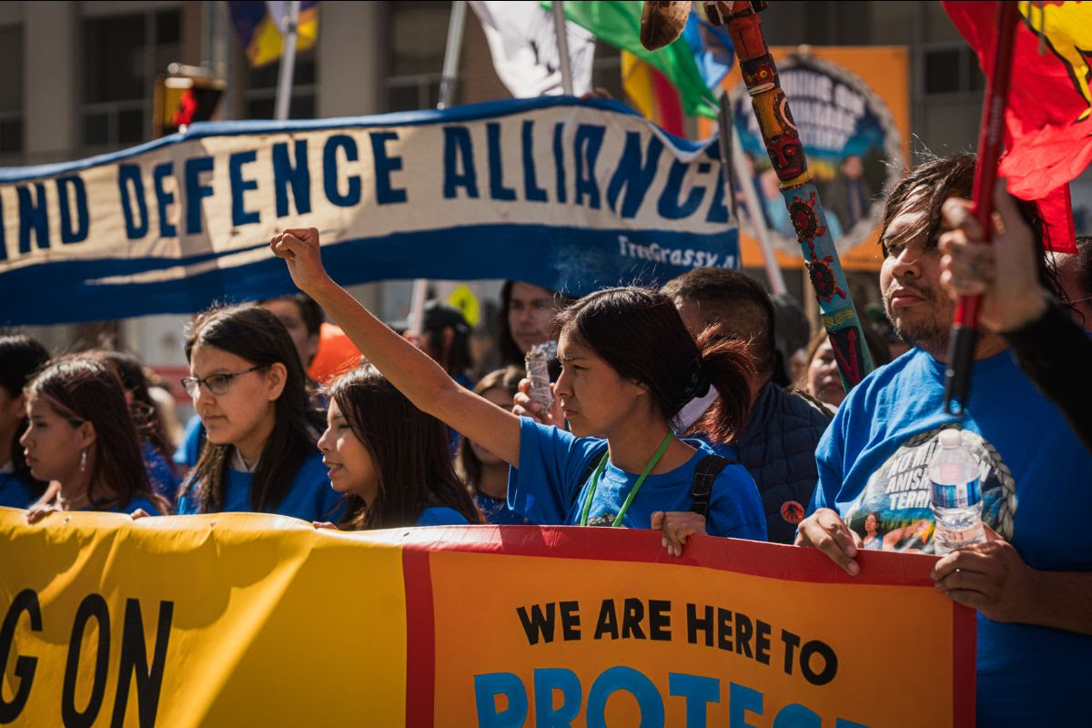 A group of people holding up banners about Indigenous rights