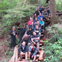 Trail building volunteers sitting on a staircase they just made in Clayoquot sound