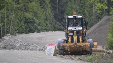 Construction truck in a mining site in the forest. End of image description. 