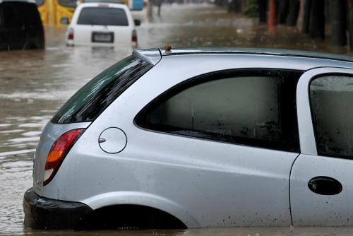 Cars in a flooded street, with water past their wheel hubs