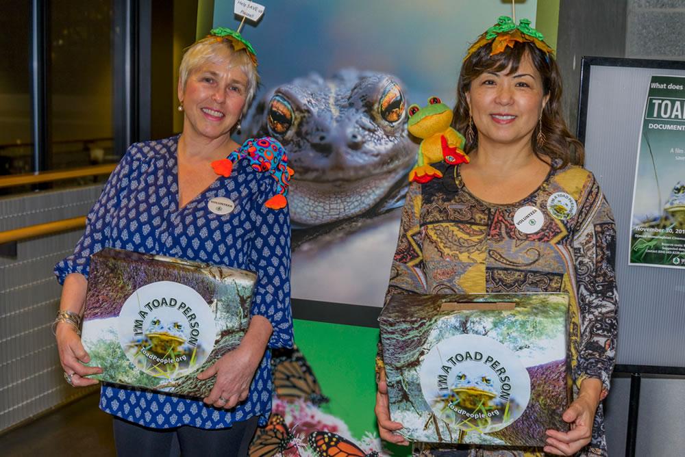 Two volunteers dressed up in toad attire and holding donation boxes.