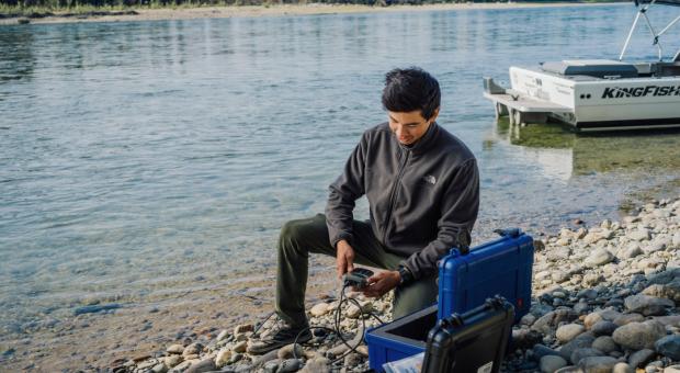 Jordan, a Kaska land guardian, conducts water sampling along the Kechika River in northern B.C. Photo: Taylor Roades / The Narwhal