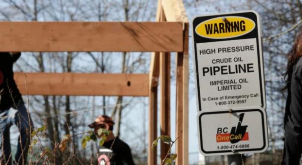 Workers building a house near Kinder Morgan’s Trans Mountain Pipeline Burnaby Terminal in British Columbia in March 2018. (Photo: Jason Redmond, AFP via Getty Images)