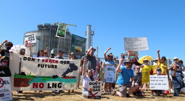 People protesting outside Tilbury LNG facility in Delta, BC. Their signs say "Don't frack our future, NO LNG" and "Don't add gas".