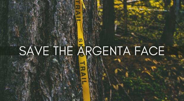 "Save the Argenta Face" appears on a big tree trunk with a piece of flagging tape hanging from it.
