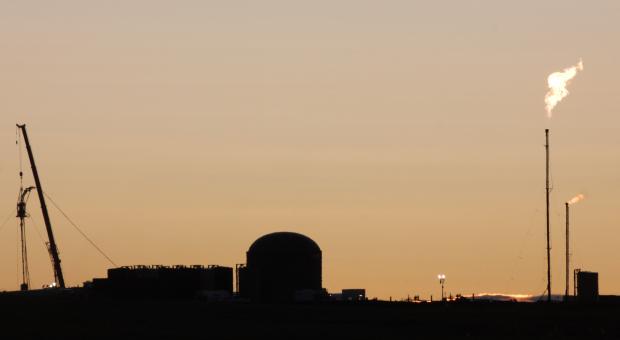 Skyline of a fracking plant with its flare stack burning away.