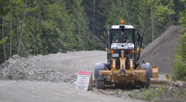 Construction truck in a mining site in the forest. End of image description. 