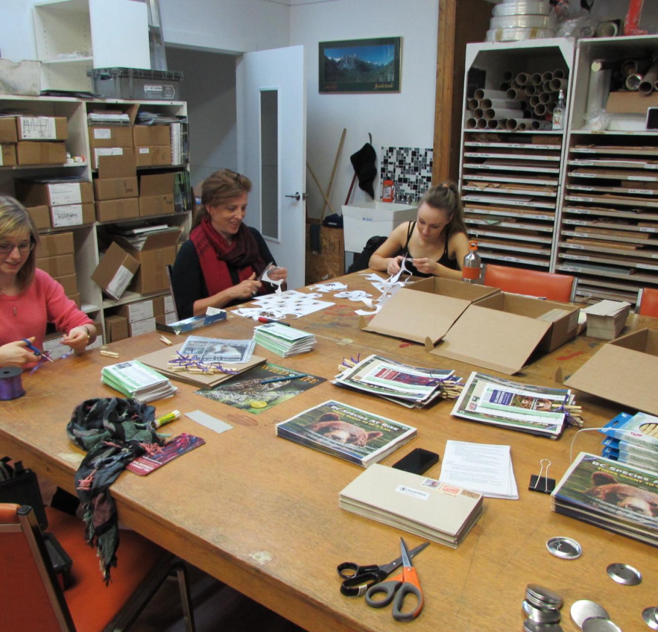 Volunteers having fun stuffing envelopes around a large table