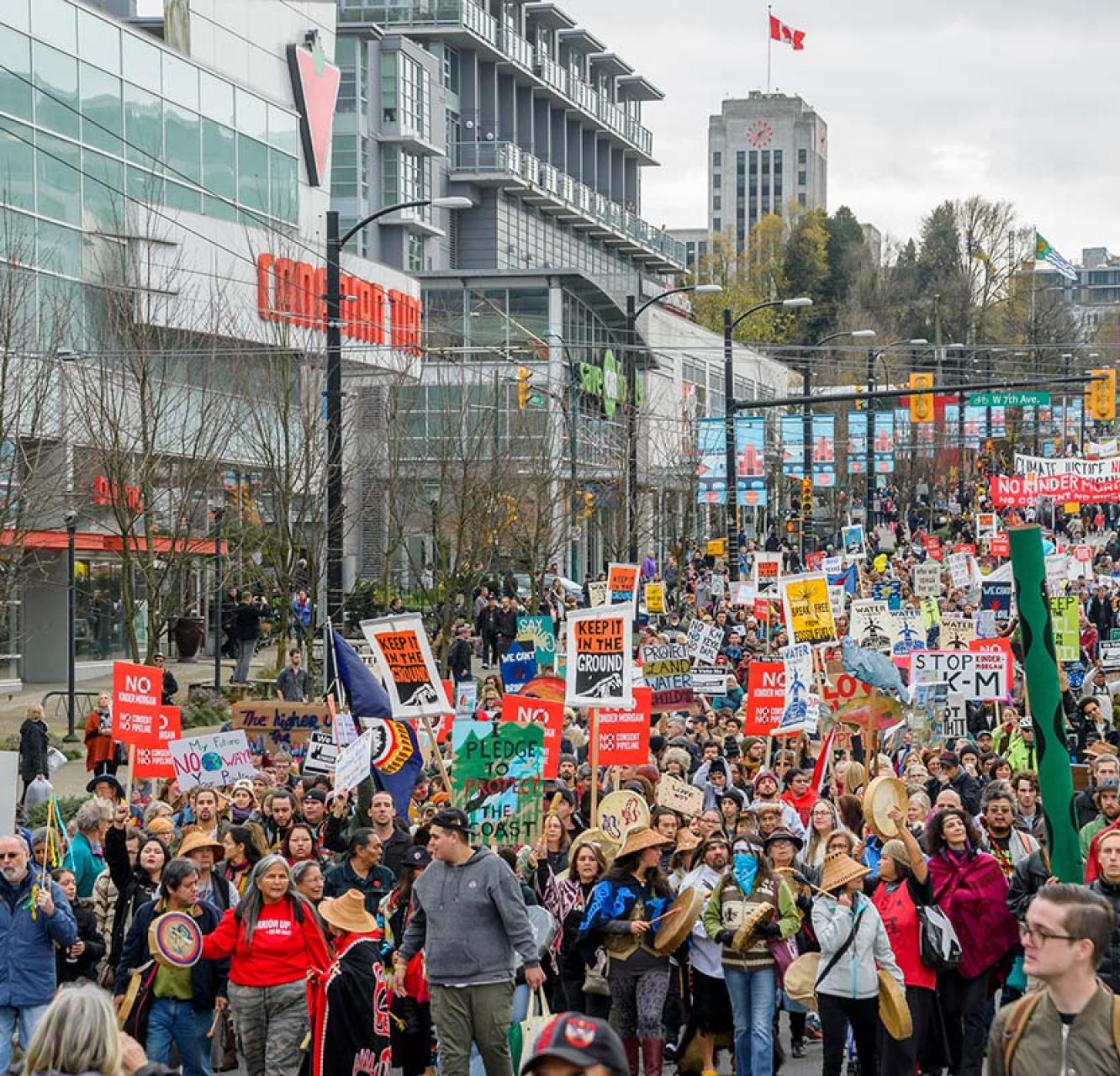 A large group protesting by marching down Cambie Street in Vancouver