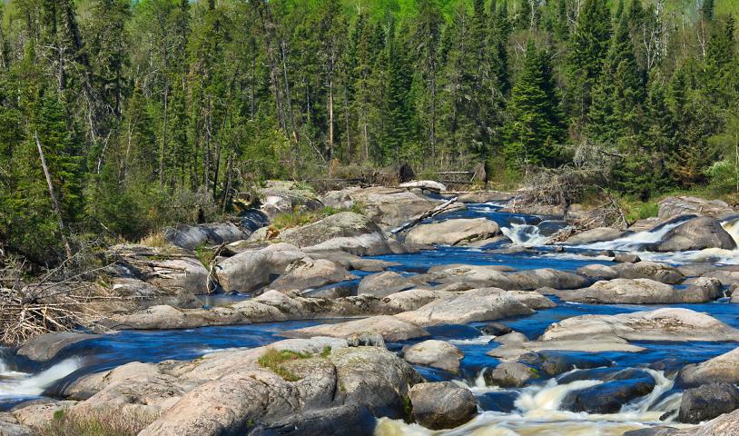 A rocky stream with text over the image that says "30 by 30, opportunities and challenges." End of image description. 