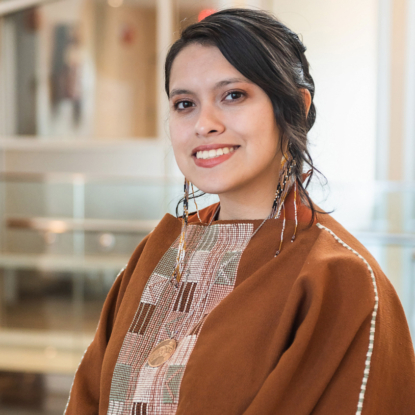 Smiling woman in patterned clothing and beaded earrings
